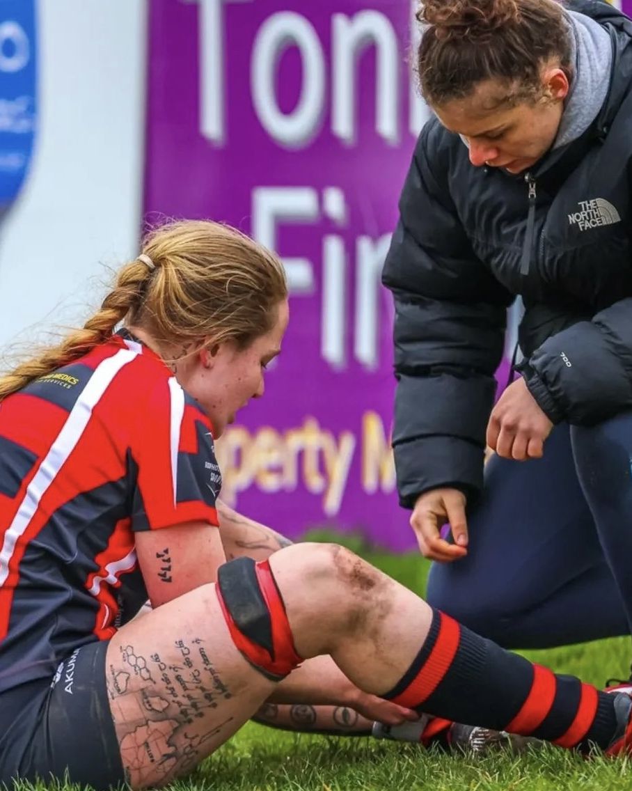Mimi Paton, HCPC-registered physiotherapist, assessing a rugby player's knee pitch-side